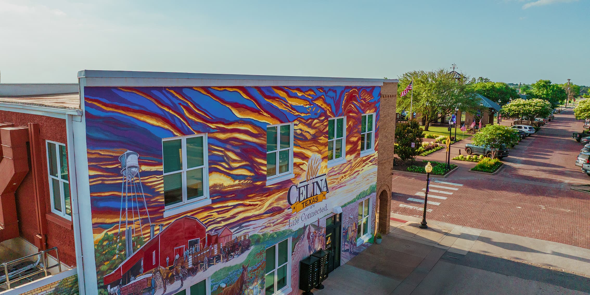 A storefront with a Celina Texas mural painted on the side.