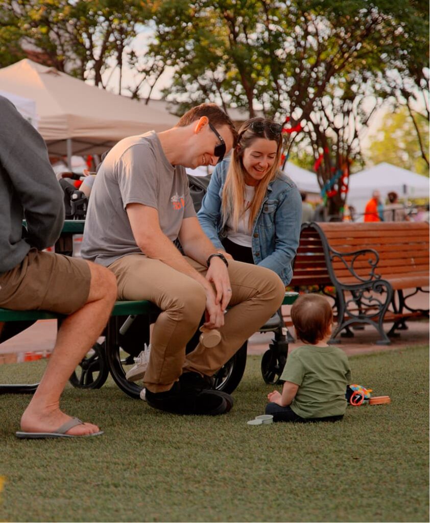 A couple playing with their child in a park.