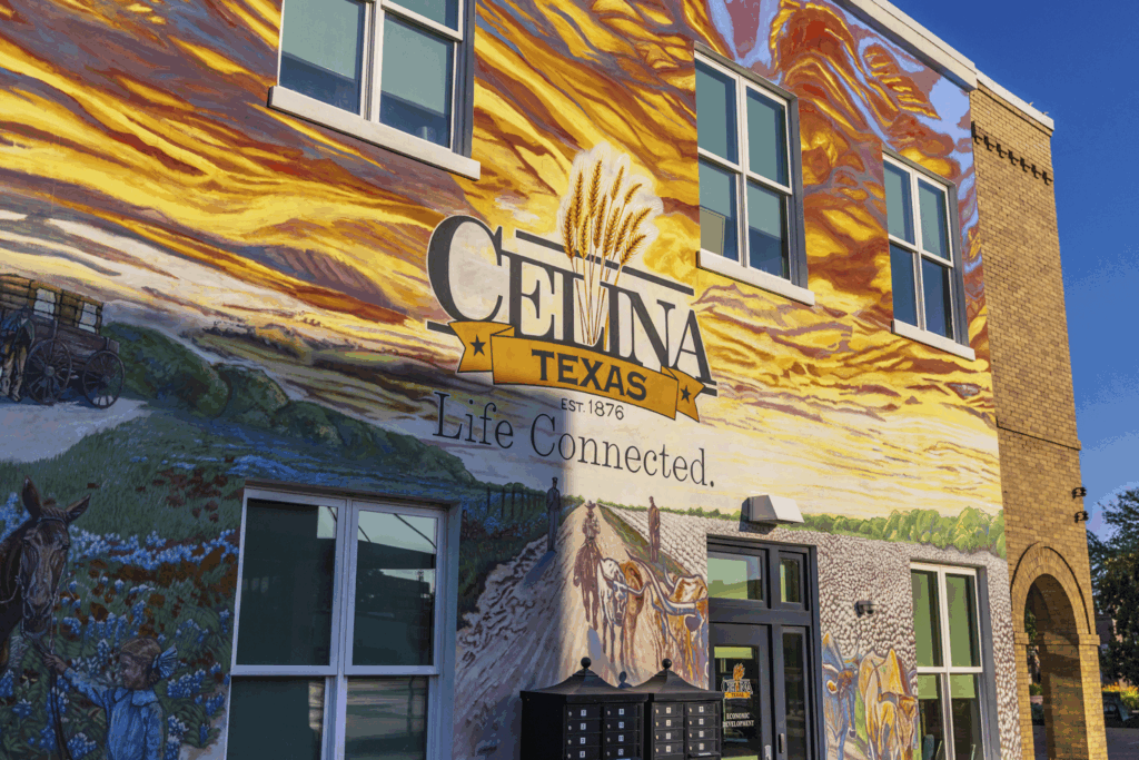 A mural on a building wall in Celina, Texas, displays the city name, wheat stalks, "Life Connected," and colorful landscape artwork.